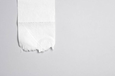 Gri arka planda beyaz delikli tuvalet kağıdı parçası