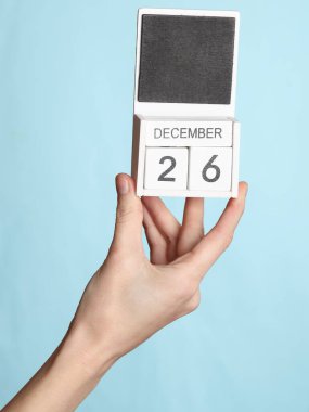 26 Aralık tarihli ahşap takvim, mavi arkaplanda izole edilmiş.