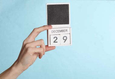 29 Aralık tarihli ahşap takvim, mavi arkaplanda izole edilmiş.