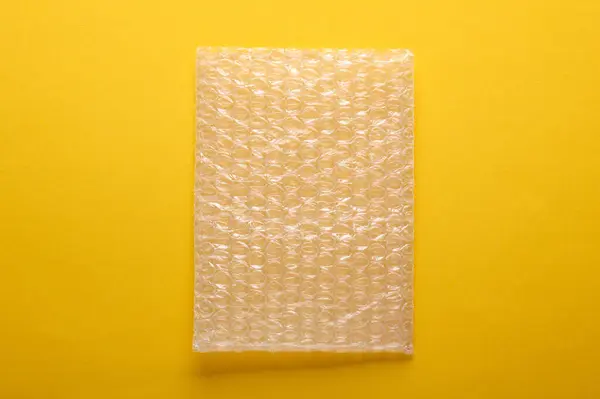 Shockproof wrapping film with bubbles for transportation on yellow background
