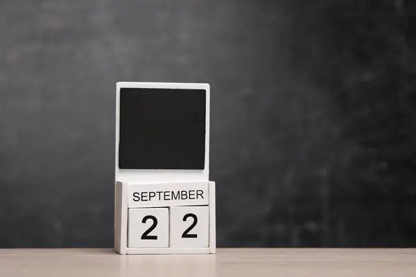 Calendar with september 22 date on table against chalk board background