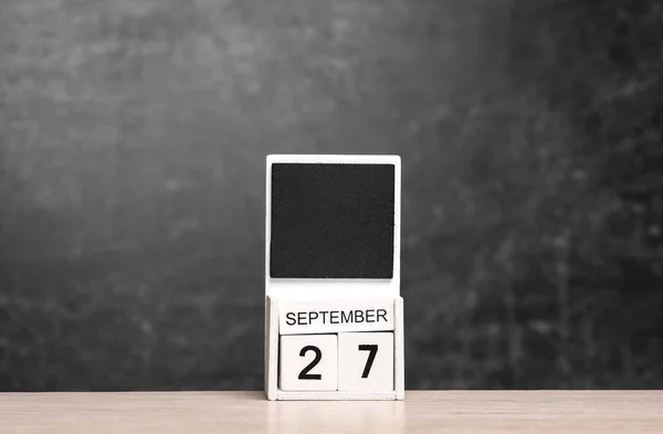 Calendar with september 27 date on table against chalk board background