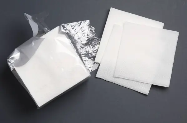 Opened package of paper napkins on a black background