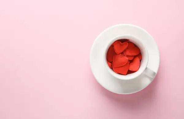 stock image Ceramic coffee cup with red hearts on pink blue background. Love concept. Top view