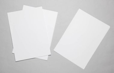 A4 kâğıt büyüklüğünde beyaz boş kağıtlar ya da gri arka planda sahte belgeler. Tasarım şablonu