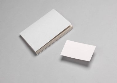 Gri arka planda beyaz kapaklı ve kartvizitli kitap modeli