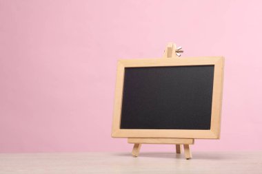 Üç ayaklı küçük tebeşir tahtası, pembe arkaplan