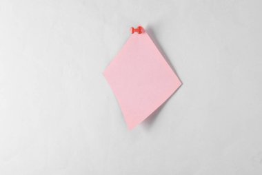 Gri arkaplana yerleştirilmiş pembe kare not kağıdı