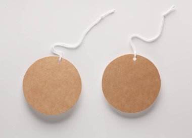 Boş yuvarlak el işi kağıt fiyat etiketleri ve gri arka planda ip. Tasarım şablonu