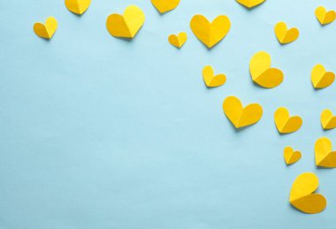 Mavi arka planda kağıt kesiği olan sarı kalpler. Aşk, romantik konsept. Yaratıcı düzen. Üst Manzara. Boşluğu kopyala