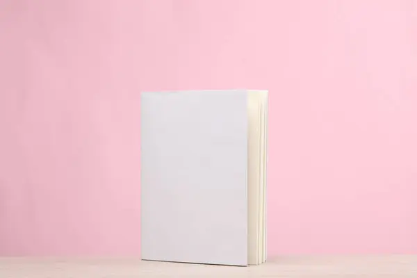 Book with white cover on pink background