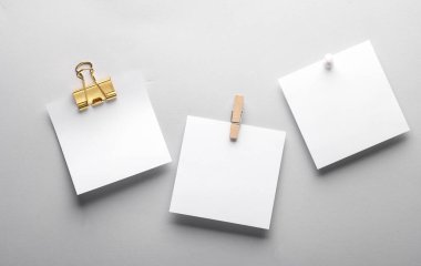 Gri arka planda beyaz, boş, not kağıtları, klasörü, iğnesi ve iğnesi var. Tasarım şablonu.