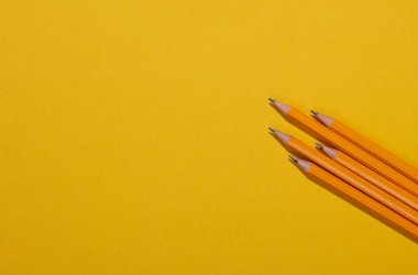 Sarı arka planda kalemler. Yaratıcı asgari düzen