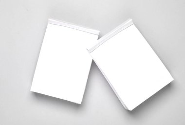 Gri arka planda beyaz kağıt çantalar.