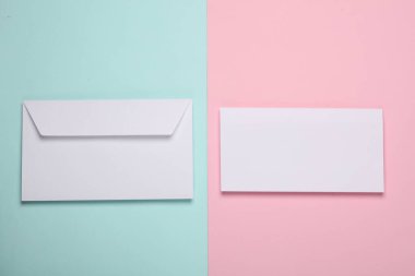 Pembe mavi arka planda boş harfli, yaratıcı, beyaz bir zarf. Düz yatıyordu