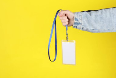 Sarı arkaplanda beyaz kimlik kartı var.