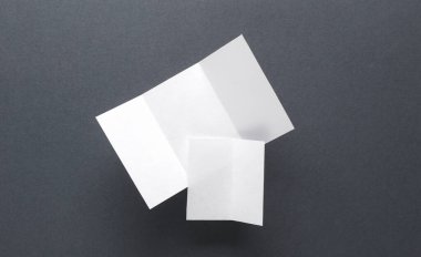 Beyaz, gri arkaplan üzerine kağıt broşürler hazırlıyor.