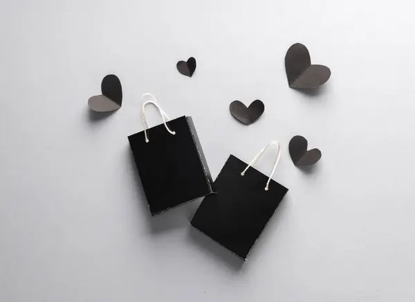 Sale, creative layout. Black shopping bags and hearts. Black Friday. Top view
