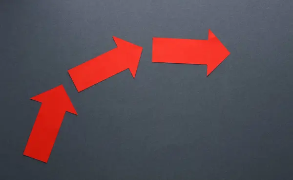 Paper red pointing arrows on a gray background