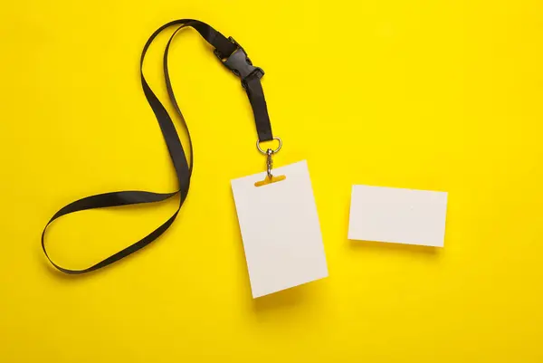Empty white ID card badge and business card on yellow background. Template for design