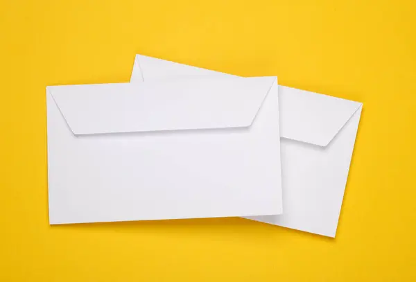 Two white envelopes on a yellow background. Template for design