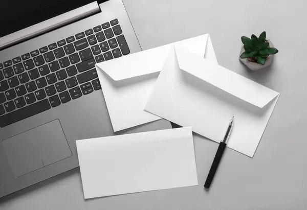 Creative business layout from white envelope with a letter and laptop on a gray background. Template for design