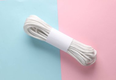 Pembe arka planda beyaz, boş etiketli beyaz halat bobini. Tasarım ve markalaşma şablonu