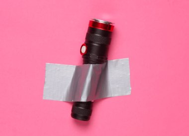 El feneri, pembe arka planda yapıştırıcı bantla sabitlenmiş. Kavramsal pop, çağdaş sanat, minimalist natüralist hayat