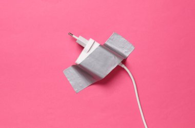 Pembe arka planda yapıştırıcı bant ile şarj ediliyor. Kavramsal pop, çağdaş sanat, minimalist natüralist hayat