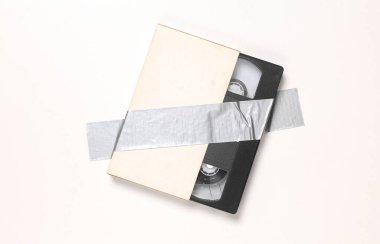 Video kaseti beyaz arkaplanda yapıştırıcı bantla sabitlendi. Kavramsal pop, çağdaş sanat, minimalist natüralist hayat