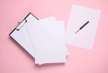 Boş kağıtlı bir pano ve pembe arka planda bir kalem. İş konsepti. Tasarım şablonu