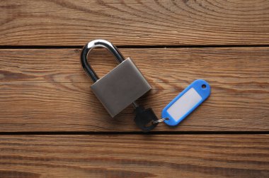 Metal anahtarı olan plastik etiket ve ahşap masaya kilitlenmiş.