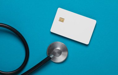 Üzerinde çip ve steteskop olan beyaz bir banka kartı. İş ve Finans