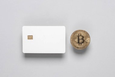 Gri zemin üzerinde çip ve bitcoin olan beyaz, boş bir banka kartı modeli. Tasarım şablonu.