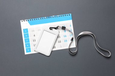 Kemerinde kimlik kartı olan kağıt takvim sayfası, koyu arkaplan