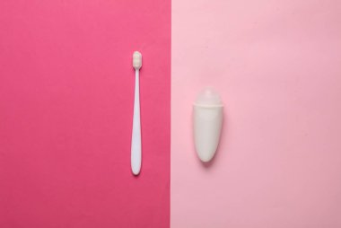 Pembe arka planda terleme önleyici silindirli diş fırçası. Temizlik.