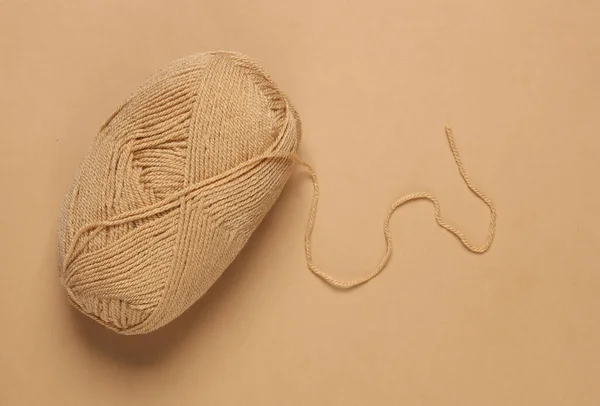 Skein of brown woolen threads on a brown background