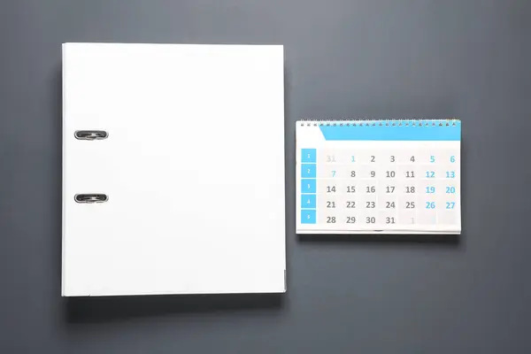 Binder folder with paper calendar on gray background