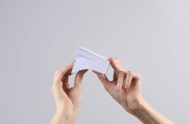 Kadın ellerinde bir yığın kağıt, gri arka plan. İş konsepti