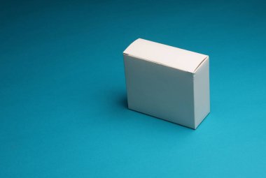Mavi arkaplanda boş beyaz karton kutu