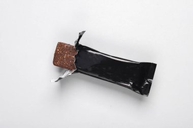 Gri arkaplanda siyah çikolata veya protein çubuğu ambalajı