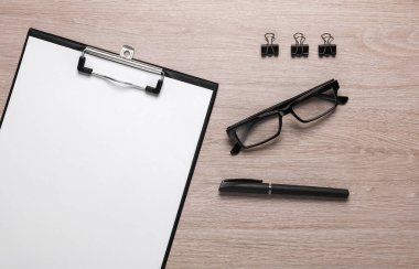 Masada beyaz kağıt ve ofis aksesuarları olan bir pano.