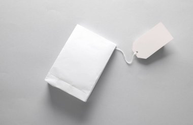 Gri arkaplanda beyaz fiyat etiketli beyaz ürün paketi
