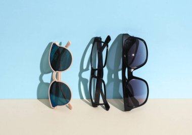 Mavi bej arka planda gözlük ve senkronizasyon. Yaratıcı düzen. Moda konsepti