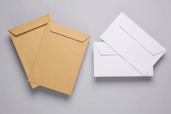Craft and white postal envelopes on a gray background