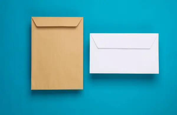 Craft and white postal envelopes on blue background