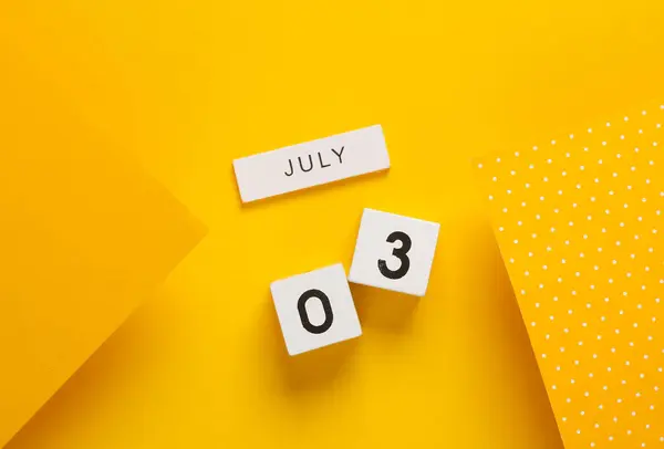 White calendar cubes with date july 03 on yellow background. Creative layout
