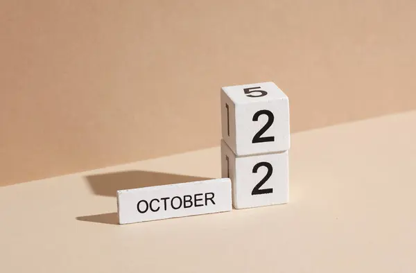 Wooden white block calendar with date october 22 on beige background with shadow. Creative layout, planning, holiday