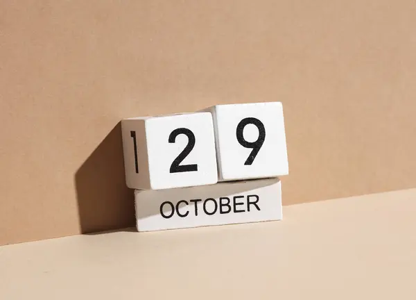 Wooden white block calendar with date october 29 on beige background with shadow. Creative layout, planning, holiday