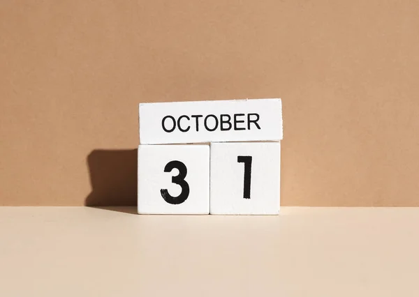 Wooden white block calendar with date october 31 on beige background with shadow. Creative layout, planning, holiday